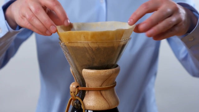 Chemex Classic Series 3-cup pour-over glass coffeemaker with wooden collar and leather tie, designed for brewing coffee.