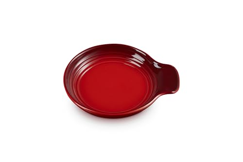 Le Creuset Signature Cerise stoneware spoon rest, 6 inches, with smooth, curved design for kitchen countertop use.